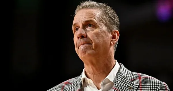 Close-up of a basketball coach in a red and black plaid sport coat looking up