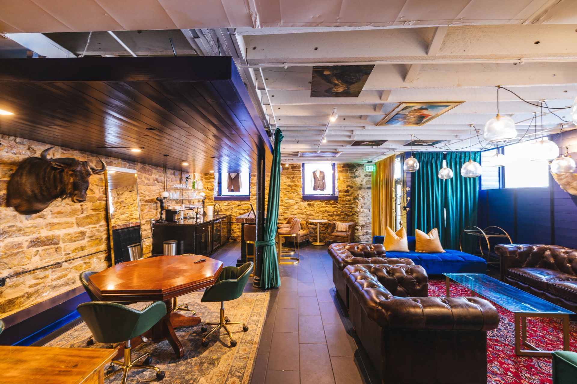 H Club Fayetteville lounge with stone walls, leather seating and a bar