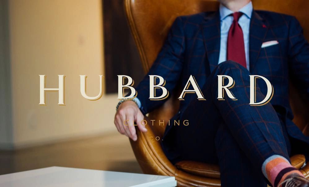 Hubbard Clothing Co. logo over a gentleman seated in a navy suit