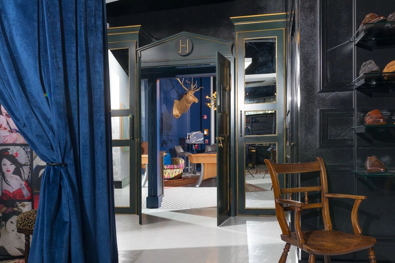 Dark wood wardrobe and navy drapes inside Hubbard Clothing Co.